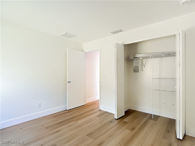 unfurnished bedroom featuring light hardwood / wood-style floors and a closet