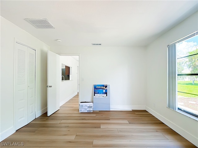 unfurnished bedroom featuring light hardwood / wood-style floors and multiple windows