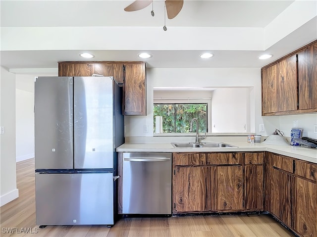 kitchen with ceiling fan, sink, stainless steel appliances, and light hardwood / wood-style flooring