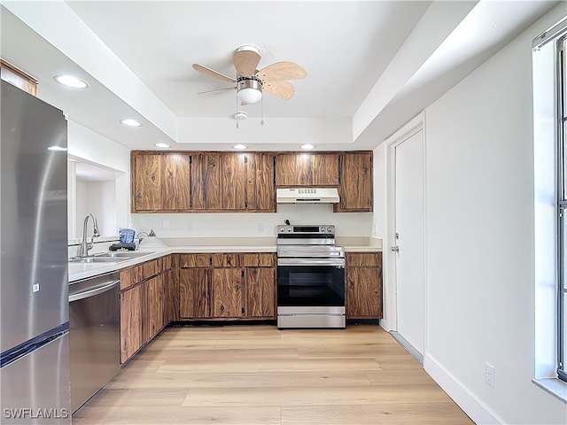 kitchen with appliances with stainless steel finishes, ceiling fan, light hardwood / wood-style floors, and sink