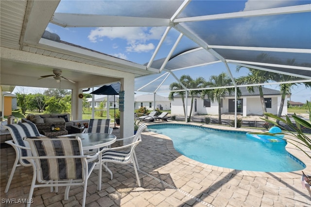 view of swimming pool featuring glass enclosure, ceiling fan, and a patio