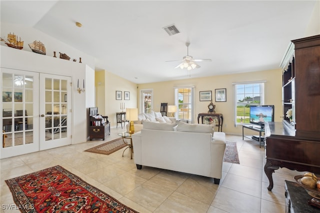 tiled living room with vaulted ceiling, ceiling fan, and french doors