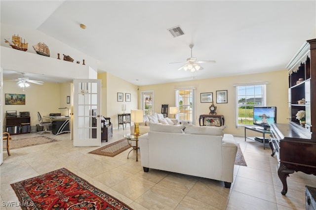 tiled living room with lofted ceiling, ceiling fan, and french doors