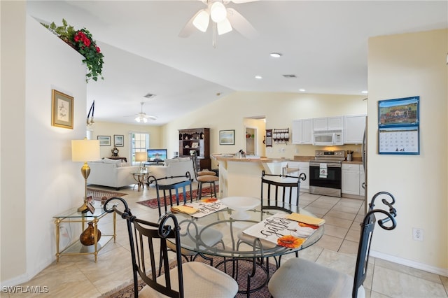 tiled dining area featuring ceiling fan and vaulted ceiling