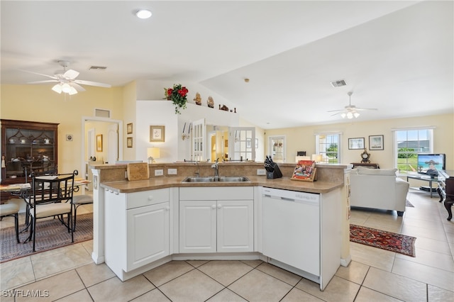 kitchen with vaulted ceiling, white cabinets, dishwasher, ceiling fan, and a center island with sink