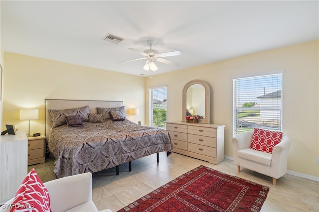 tiled bedroom with ceiling fan and multiple windows