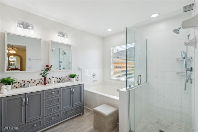 bathroom with hardwood / wood-style floors, vanity, and separate shower and tub