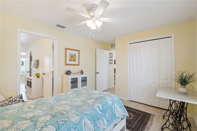 tiled bedroom with ceiling fan and a closet