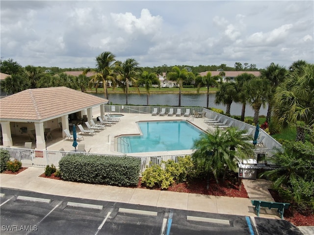 view of swimming pool with a water view, a patio area, and a gazebo