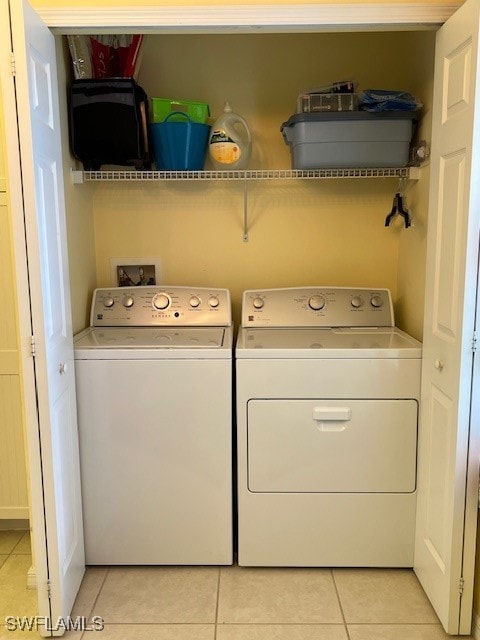 washroom with washing machine and clothes dryer and light tile patterned floors