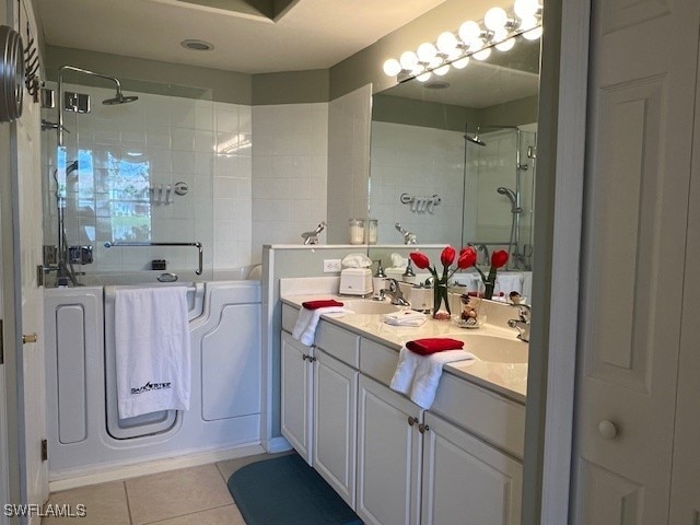 bathroom with tile patterned flooring, an enclosed shower, and vanity