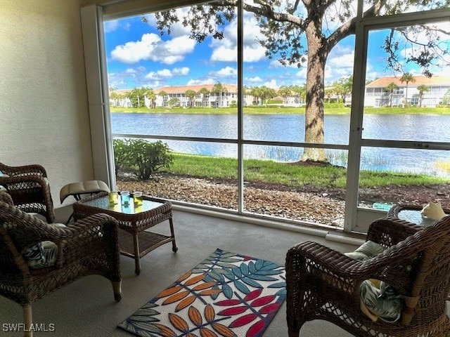 sunroom featuring a water view