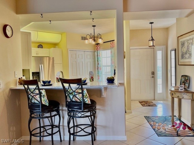 kitchen featuring hanging light fixtures, kitchen peninsula, a breakfast bar area, and stainless steel refrigerator with ice dispenser