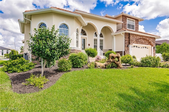 mediterranean / spanish-style home featuring a front lawn and a garage