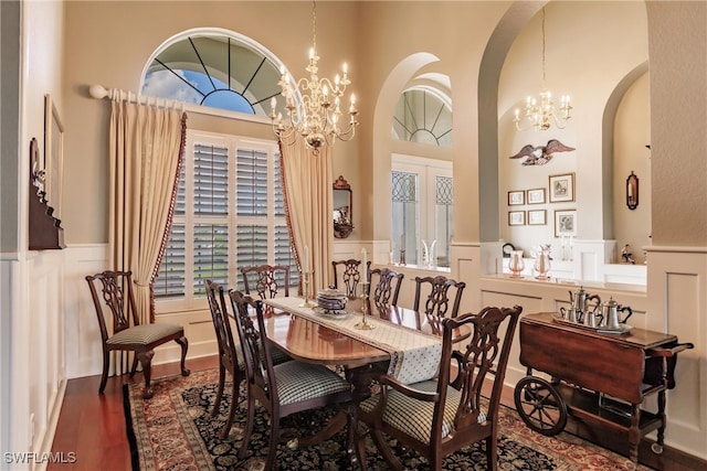 dining area featuring an inviting chandelier, a high ceiling, and wood-type flooring