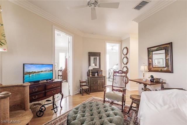 living area featuring ceiling fan, light hardwood / wood-style flooring, and ornamental molding