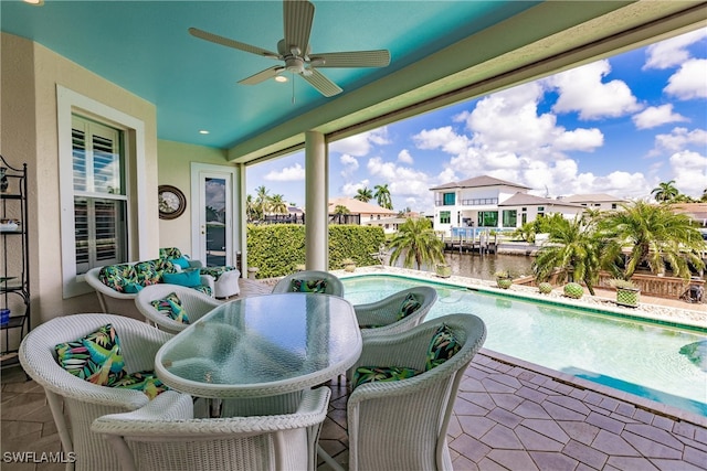 exterior space featuring ceiling fan and a water view