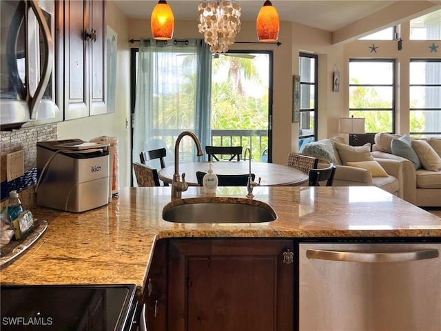 kitchen featuring appliances with stainless steel finishes, a sink, plenty of natural light, and hanging light fixtures