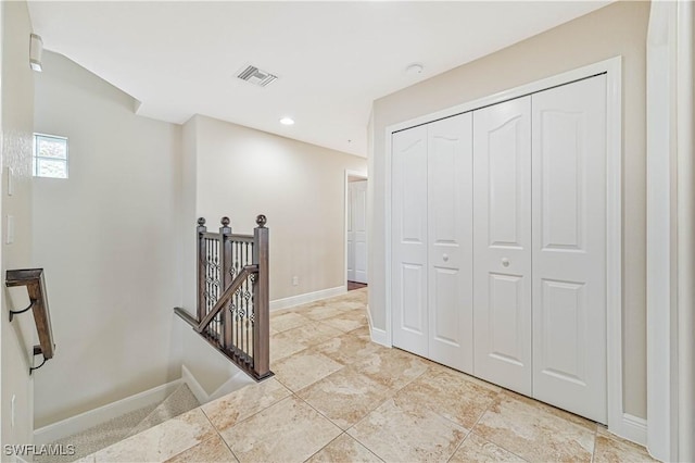 corridor featuring recessed lighting, visible vents, baseboards, and an upstairs landing