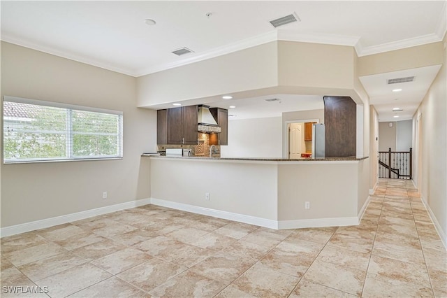 kitchen featuring ornamental molding, custom range hood, visible vents, and baseboards