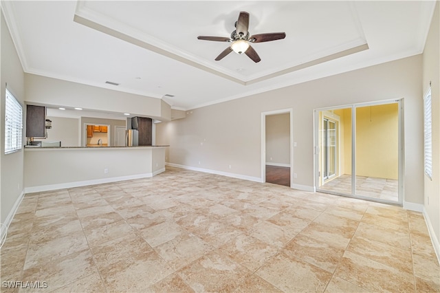 unfurnished living room featuring ornamental molding, ceiling fan, and a raised ceiling