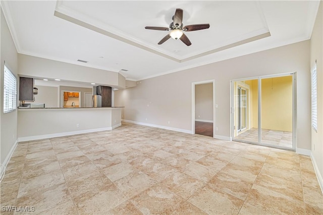 unfurnished living room with crown molding, a raised ceiling, visible vents, a ceiling fan, and baseboards