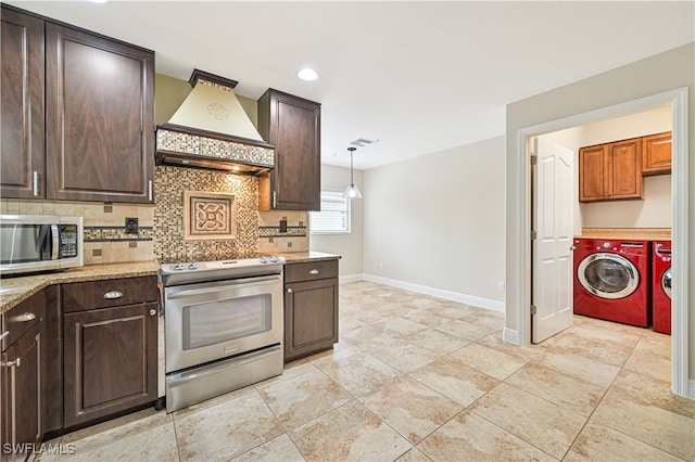 kitchen featuring decorative backsplash, appliances with stainless steel finishes, pendant lighting, separate washer and dryer, and premium range hood