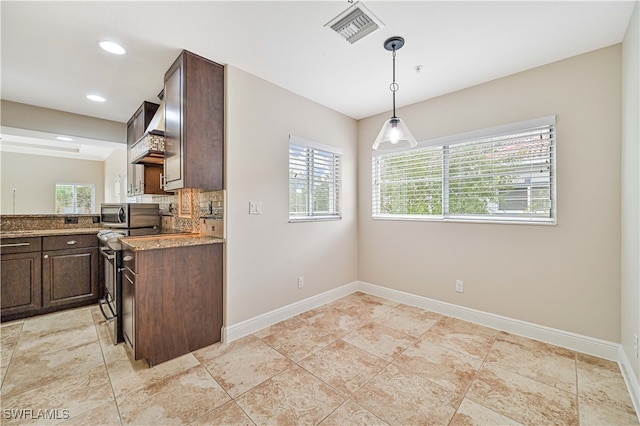 kitchen featuring decorative backsplash, hanging light fixtures, dark brown cabinets, and a wealth of natural light