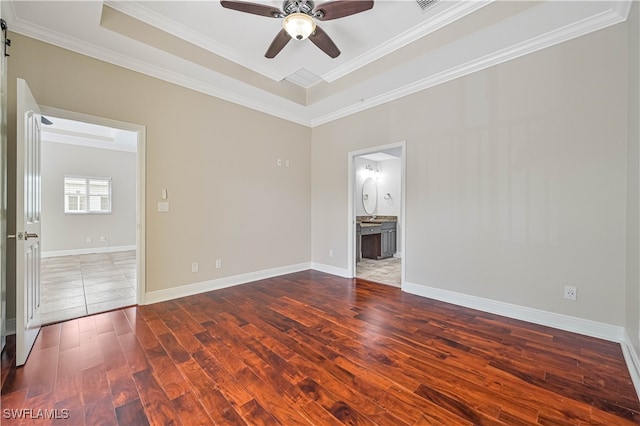 spare room featuring crown molding, a raised ceiling, dark hardwood / wood-style floors, and ceiling fan