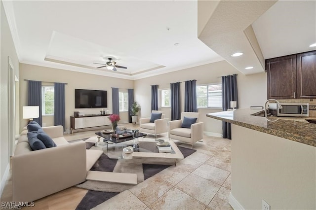 living room with ornamental molding, a healthy amount of sunlight, and ceiling fan