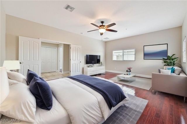 bedroom with a ceiling fan, visible vents, dark wood finished floors, and baseboards