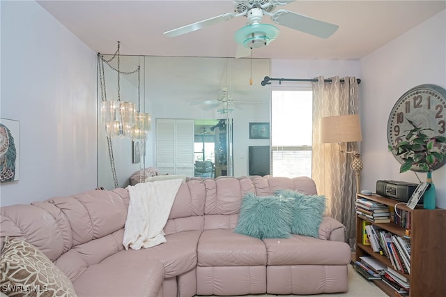 living room with ceiling fan with notable chandelier