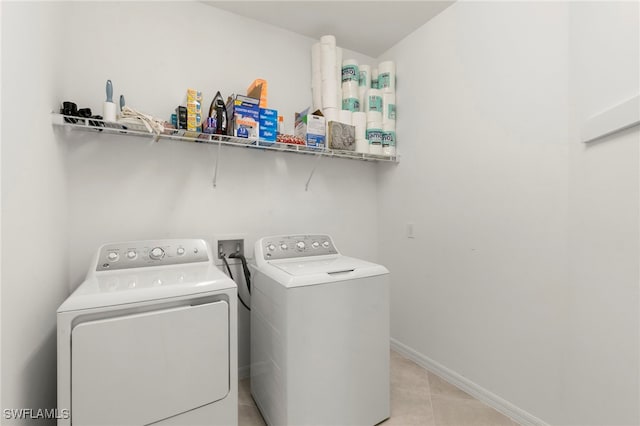 washroom featuring washer and clothes dryer and light tile patterned flooring