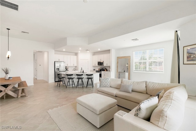 living room with light tile patterned floors and sink