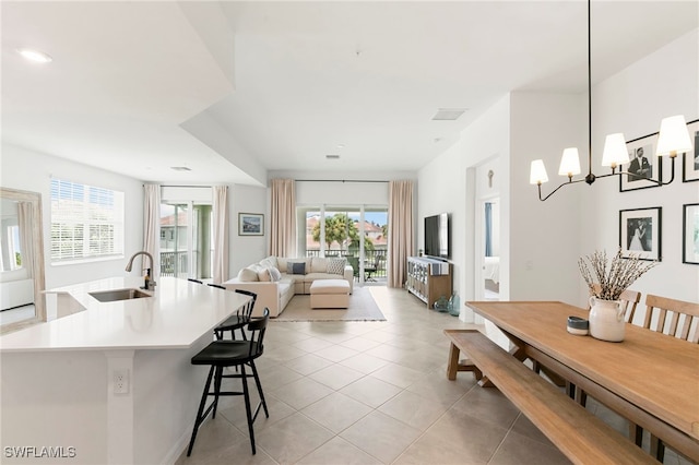 dining area with sink, light tile patterned floors, and a chandelier