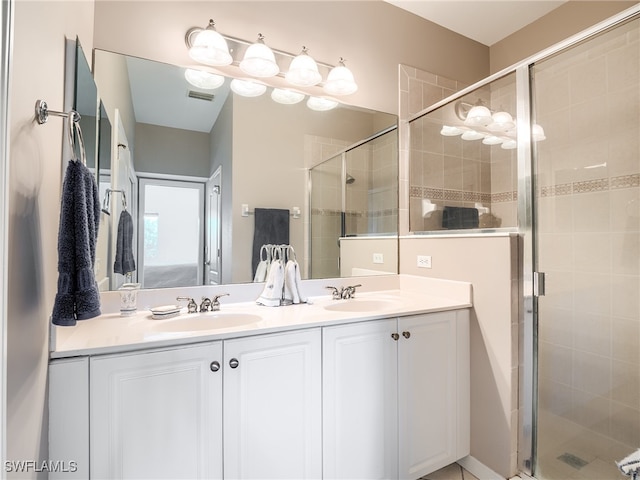 bathroom with a shower with shower door and vanity