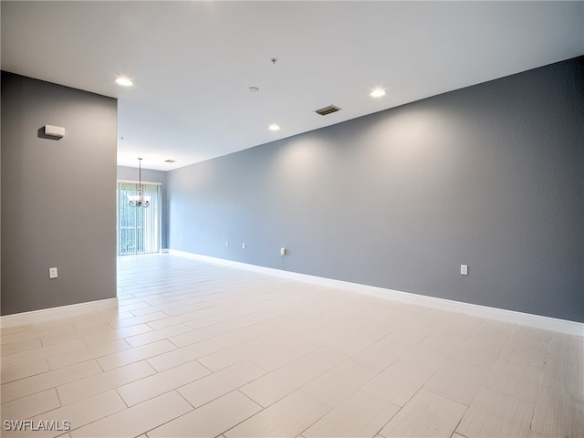 unfurnished room with an inviting chandelier