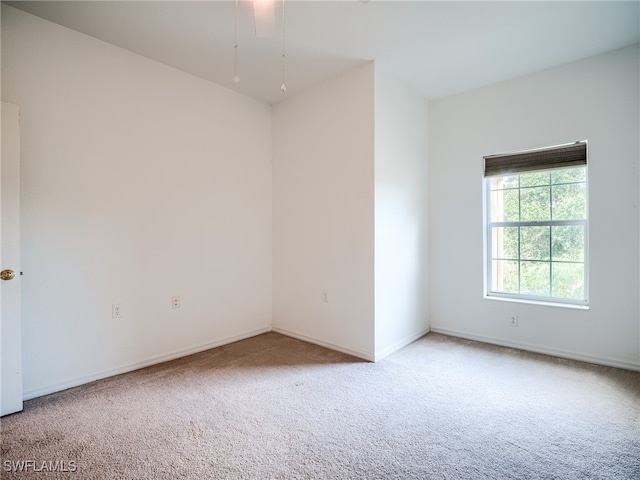 carpeted spare room featuring ceiling fan