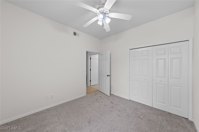 unfurnished bedroom with a closet, ceiling fan, and light carpet