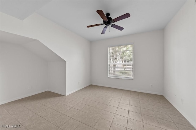 empty room with light tile patterned floors, ceiling fan, and baseboards