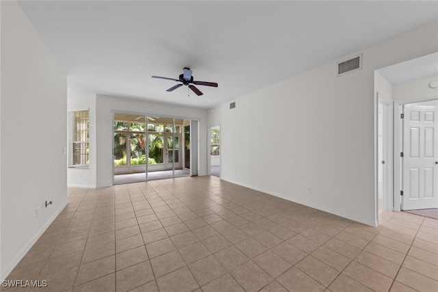 unfurnished room with light tile patterned floors, ceiling fan, visible vents, and baseboards