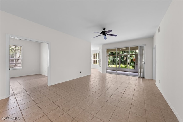 tiled spare room featuring ceiling fan