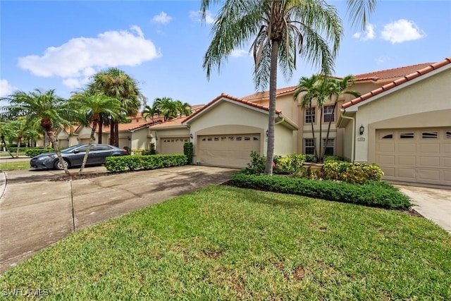 view of front of home featuring driveway, a garage, stucco siding, a tiled roof, and a front yard