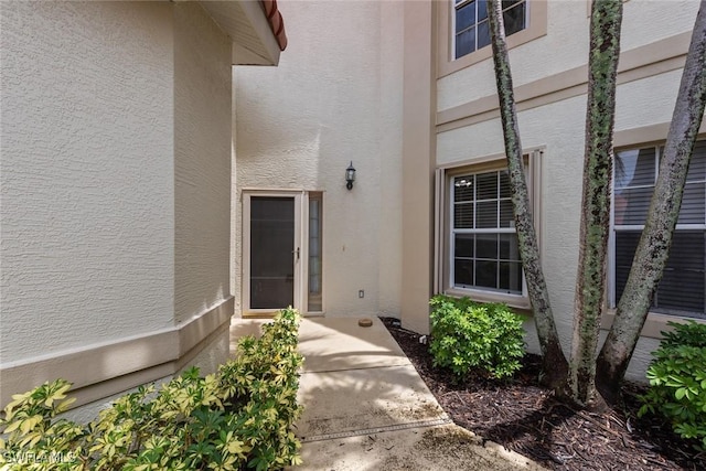 property entrance with stucco siding