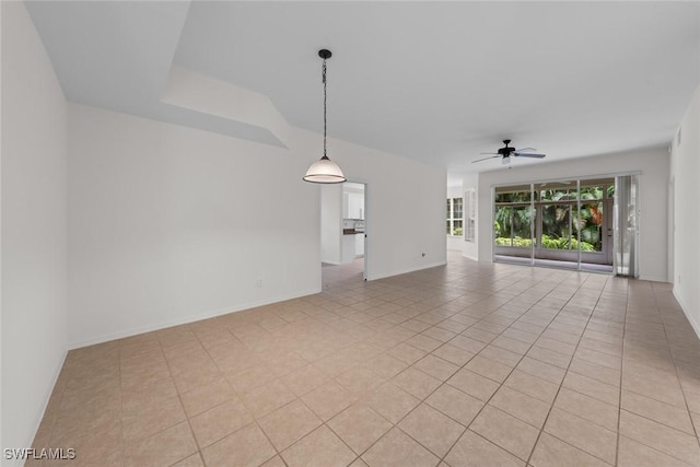 unfurnished living room featuring a ceiling fan, baseboards, and light tile patterned floors