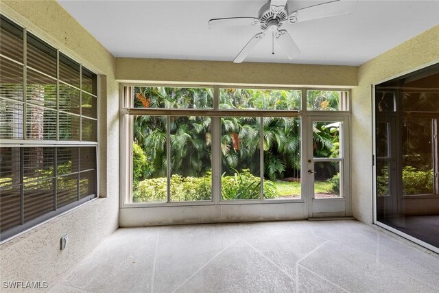 unfurnished sunroom featuring a wealth of natural light and ceiling fan