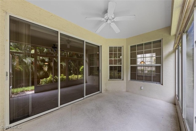 unfurnished sunroom featuring ceiling fan