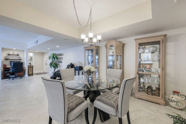 tiled dining room featuring a raised ceiling and a chandelier