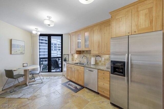 kitchen featuring appliances with stainless steel finishes, sink, light brown cabinets, and backsplash