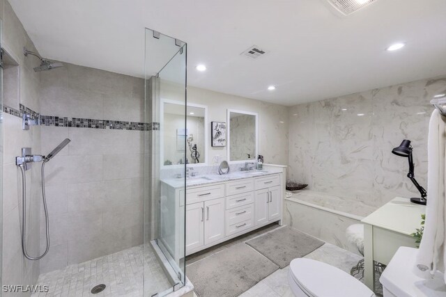 full bathroom featuring shower with separate bathtub, vanity, tile patterned flooring, tile walls, and toilet